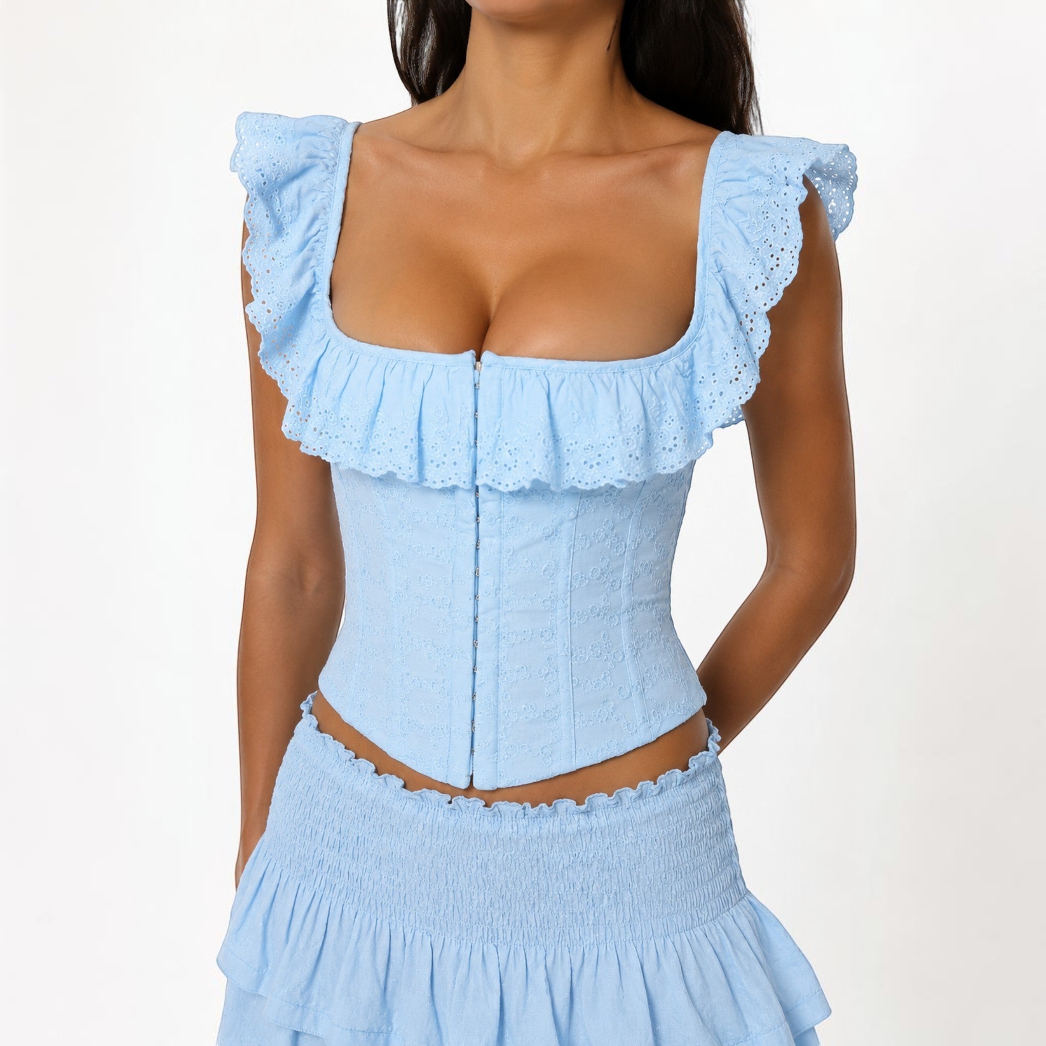 Studio Ruban light blue U-neck embroidered eyelet vest with ruffle trim and hook-and-eye front closure.