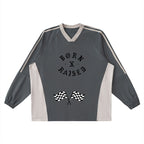 Studio Ruban grey and beige color-block long-sleeve t-shirt with V-neck and checkered flag graphic.