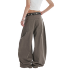 Studio Ruban Kisa taupe wide leg denim jeans with square stud embellishments and a black studded belt.