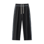 Studio Ruban black cotton blend sweatpants with drawstring waist and sunfaded side stripes. Oversized fit.