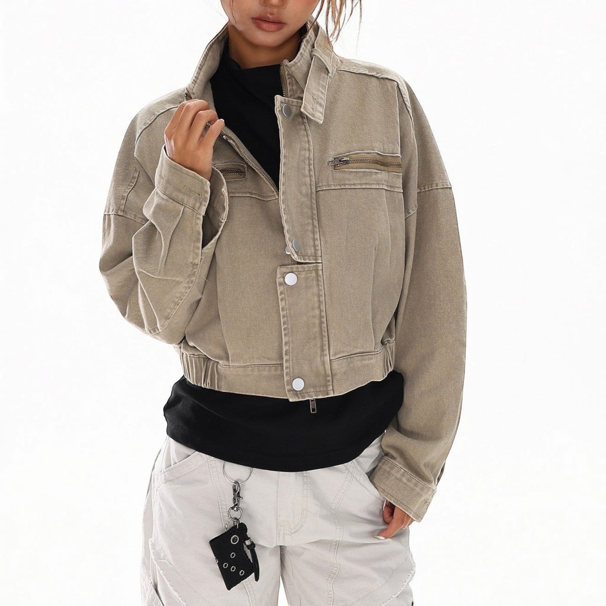 Studio Ruban women's cropped tan distressed denim jacket with stand collar and zippered pockets.